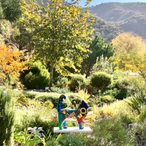 A statue of a person in the middle of a garden.