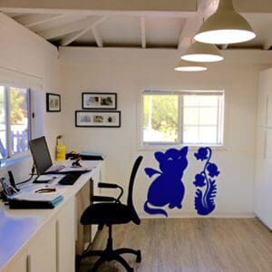 A room with a desk and chair, computer on the wall.