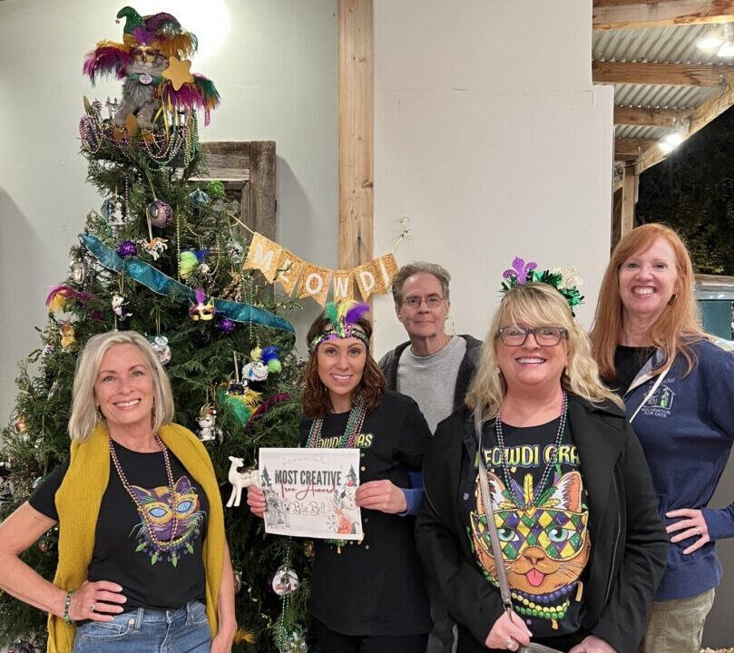 A group of people with a Christmas tree